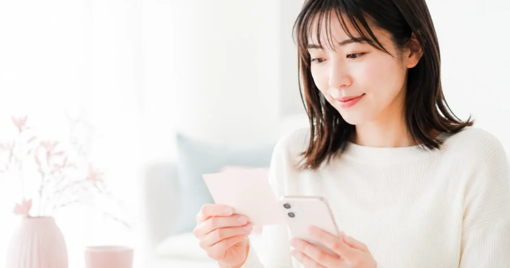 無料相談前にスマートフォンとメモで質問を整理する女性